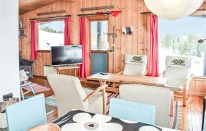 uma sala de estar com uma mesa e cadeiras e uma televisão em Amazing Home In Gol With House A Mountain View em Golsfjellet