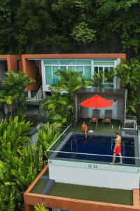 a man and a woman are playing in a pool at Novotel Phuket Kamala Beach - SHA Extra Plus in Kamala Beach