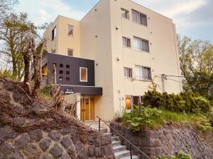 a large white building with stairs in front of it at UCHI Living Stay Otaru Suitengu in Otaru