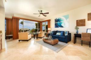 a living room with a blue couch and a ceiling fan at Kapalua Bay Villa 32G4 villa in Kahana