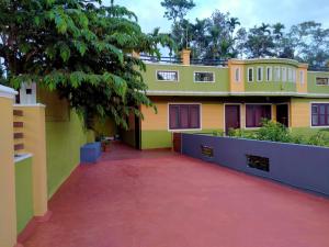 a house with a red driveway in front of it at Green Villa in Virajpet