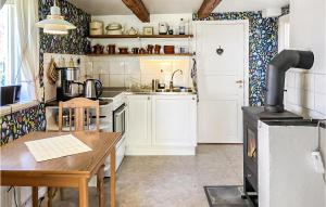 a kitchen with a wooden table and a stove at Three-Bedroom Holiday Home In Brakne Hoby in Bräkne-Hoby