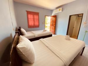 une chambre d'hôtel avec deux lits et une fenêtre dans l'établissement Phupha Bungalow Haad Rin, à Haad Rin