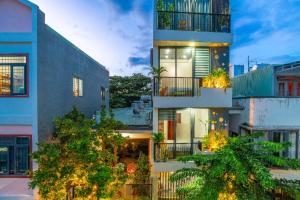 a tall building with trees in front of it at KenKeSu House-Nice 3rd floor-2BRs-Free airport pick up& drop off from 3 nights in Da Nang