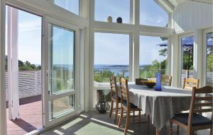 a dining room with a table and chairs and windows at Gorgeous Home In Frvik With Kitchen in Veden