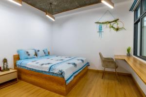 a bedroom with a bed and a desk and a chair at KenKeSu House-Nice 3rd floor-2BRs-Free airport pick up& drop off from 3 nights in Da Nang