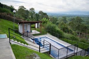 a house with a swimming pool on a hill at Apartamento a 2.5 km del parque del café in Montenegro