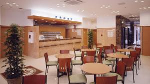 a restaurant with tables and chairs and a counter at Toyoko Inn Hiroshima-eki Minami-guchi Migi in Hiroshima