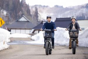 two people riding bikes down a road with helmets on at Mori no Bunkou Fuzawa - Vacation STAY 92943v in Kobayashi