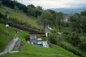 a house on a hill with a swimming pool at Apartamento con hermosa vista a 5 minutos del parque del café in Montenegro