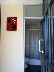 La salle de bains est pourvue de toilettes et d'une peinture murale. dans l'établissement Ecolodge Casa del Montañista, à Huaraz