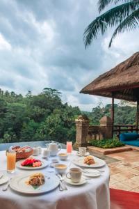 ein weißer Tisch mit Tellern voller Essen darauf in der Unterkunft Puri Wulandari A Boutique Resort & Spa in Ubud