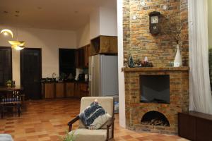 a living room with a brick fireplace with a tv at La Sen-Thu An-Có cửa sổ nhìn ra ban công in Thôn An Hòa