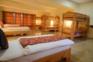 a bedroom with two beds and bunk beds in it at Munsyari The Roof Top in Munsyari