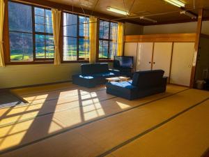 een woonkamer met 2 stoelen en een televisie bij Mori no Bunkou Fuzawa - Vacation STAY 93238v in Kobayashi
