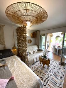 ein Wohnzimmer mit 2 Betten und einer großen Decke in der Unterkunft Studio Le paradis zen village vacances 1er étage et rdc vue mer et plage Ste Anne Guadeloupe in Sainte-Anne