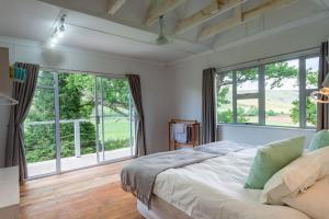 a bedroom with a large bed and large windows at Woodcliffe Country House in Woodcliffs