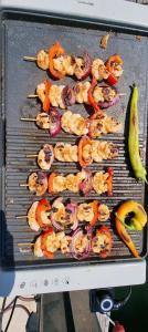 a grill with shrimp and vegetables on it at Thea - MAGIC POINT in Mangalia