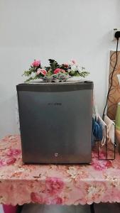 a television sitting on a table with flowers on top at HOMESTAY UMI KODIANG in Kodiang