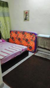 - une chambre avec un lit et un canapé orange dans l'établissement HOMESTAY UMI KODIANG, à Kodiang