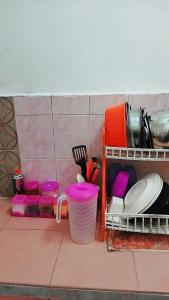 a kitchen counter with dishes and plates and utensils at HOMESTAY UMI KODIANG in Kodiang