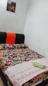 a bed with a quilt on it in a bedroom at HOMESTAY UMI KODIANG in Kodiang