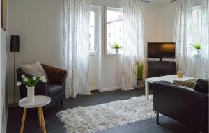 a living room with a couch and a tv at Stunning Apartment In Hlleforsns With Wifi And 2 Bedrooms in Hälleforsnäs