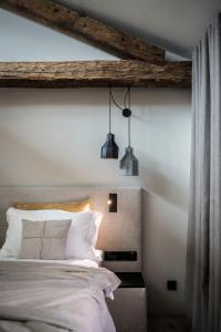 Monastero Arx Vivendi في آركو: غرفة نوم بها سرير وعلاقتين انارة