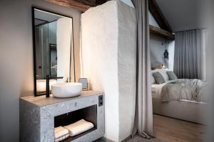 La salle de bains est pourvue d'un lavabo, d'un miroir et d'un lit. dans l'établissement Monastero Arx Vivendi, à Arco