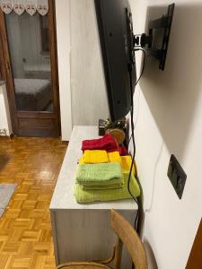telewizor siedzący na stole z ręcznikami w obiekcie Appartamento G&G w mieście Pontechianale