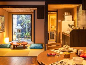 Una sala de estar con una mesa y una cocina. en 慶有魚·石塀(Kyotofish·Ishibei)*近祗园八坂神社2分钟*全屋地暖赏庭浴缸*百年町屋, en Kioto