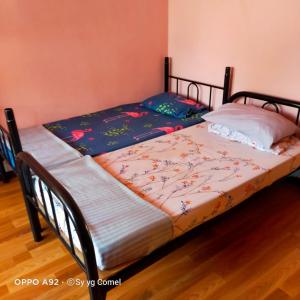 dos camas sentadas una al lado de la otra en un dormitorio en D Santai Homestay, en Kuala Terengganu