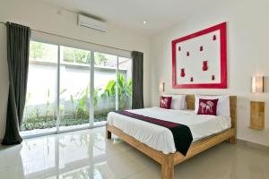 a bedroom with a large bed and a large window at 3BR Del Mar Beach Villas Near La Plancha Seminyak in Seminyak