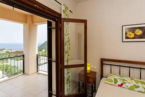a bedroom with a bed and a view of a balcony at Villa Seashell, Private Pool and Magnficent View in Ravdhoúkha +33 photos