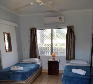 1 Schlafzimmer mit 2 Einzelbetten und einem Fenster in der Unterkunft Cooktown Motel in Cooktown