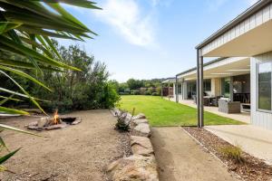 a backyard with a fire pit and a house at Coastal Chic in Saint Andrews Beach