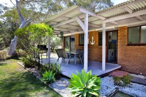 a porch of a house with a table and chairs at Wildwood I Pet Friendly I 5 Mins to Beach in Callala Beach