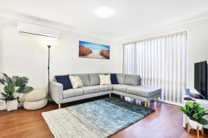 a living room with a couch and a tv at Wildwood I Pet Friendly I 5 Mins to Beach in Callala Beach