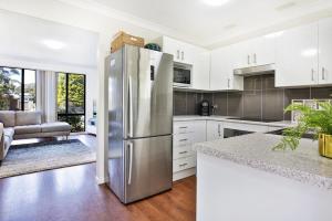 a kitchen with white cabinets and a stainless steel refrigerator at Wildwood I Pet Friendly I 5 Mins to Beach in Callala Beach