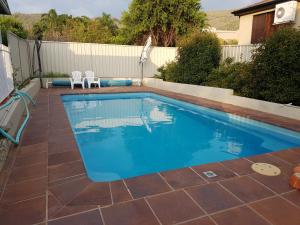a swimming pool with two chairs in a backyard at Abraham Lincoln Motel in Tamworth