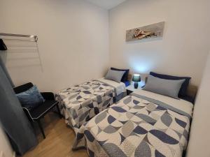 um quarto com duas camas e uma cadeira. em Seafront Apartment No 10 Marsalforn em Marsalforn