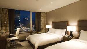 a hotel room with two beds and a window at LOTTE CITY HOTEL Mapo in Seoul