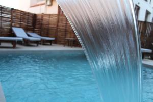 basen ze zjeżdżalnią wodną w budynku w obiekcie Mithos Premium Rooms w mieście Agia Marina Nea Kydonias