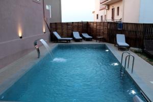 una piscina con fontana in un edificio di Mithos Premium Rooms ad Agia Marina Nea Kydonias