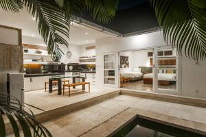 a kitchen and living room with a table and a dining room at Tides Seminyak in Seminyak