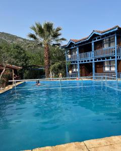 a large swimming pool in front of a hotel at Olympos Route 66 Pansiyon in Olympos