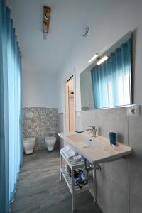 a bathroom with two sinks and two toilets at Dimora del Corso - Rooms in Mattinata