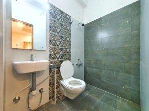 a bathroom with a toilet and a sink and a mirror at Stay Court - Business Class Hotel - Near Central Railway Station in Chennai