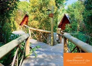 un ponte di legno su un sentiero di legno in una foresta di Lodge Roche Tamarin a La Possession