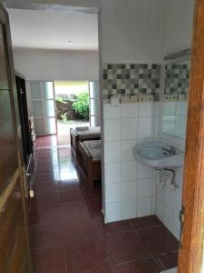 a bathroom with a sink and a bed and a mirror at Nirwana Sea Side Cottages in Lovina